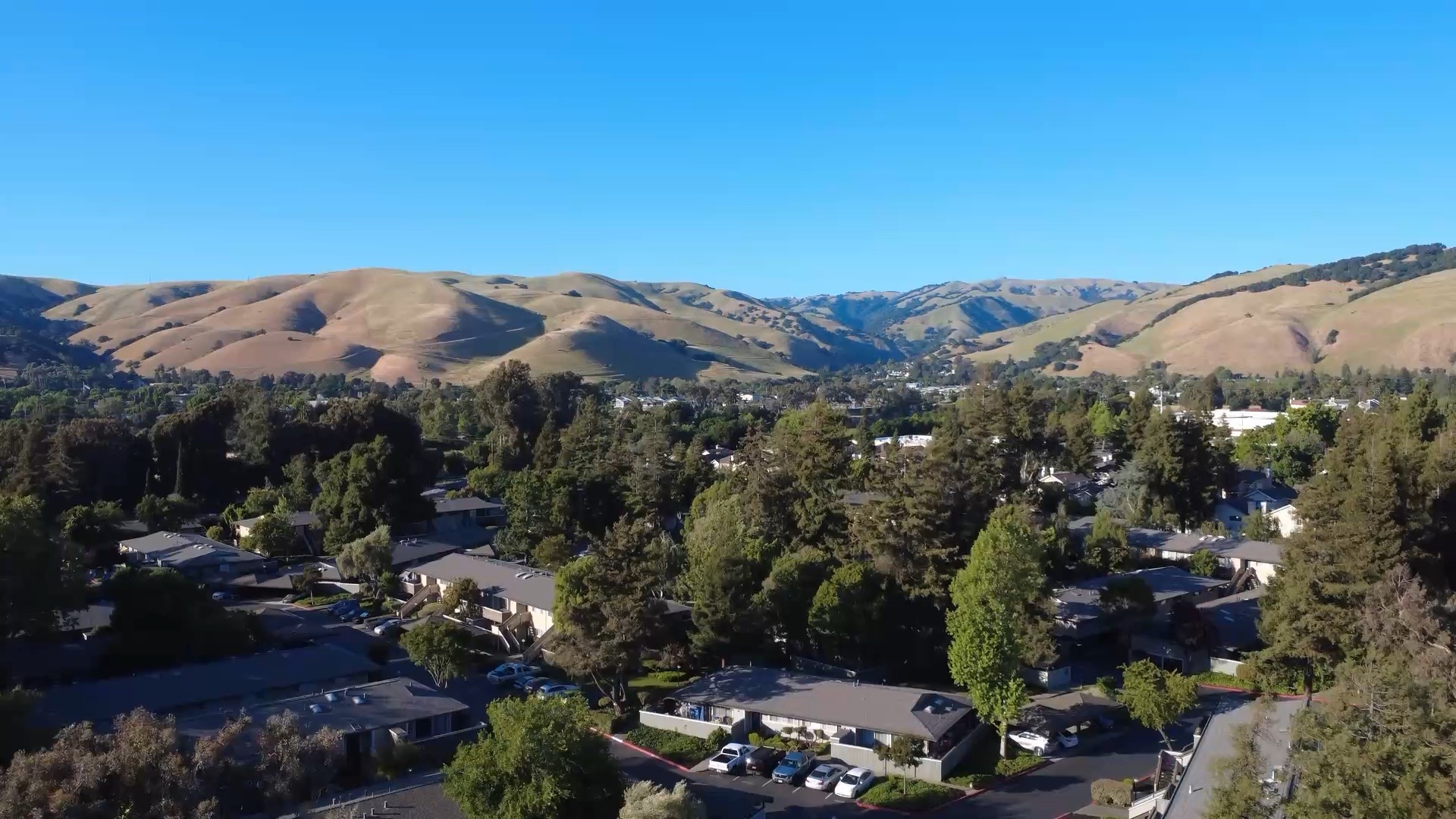 Un valle soleado de casas bajo colinas doradas