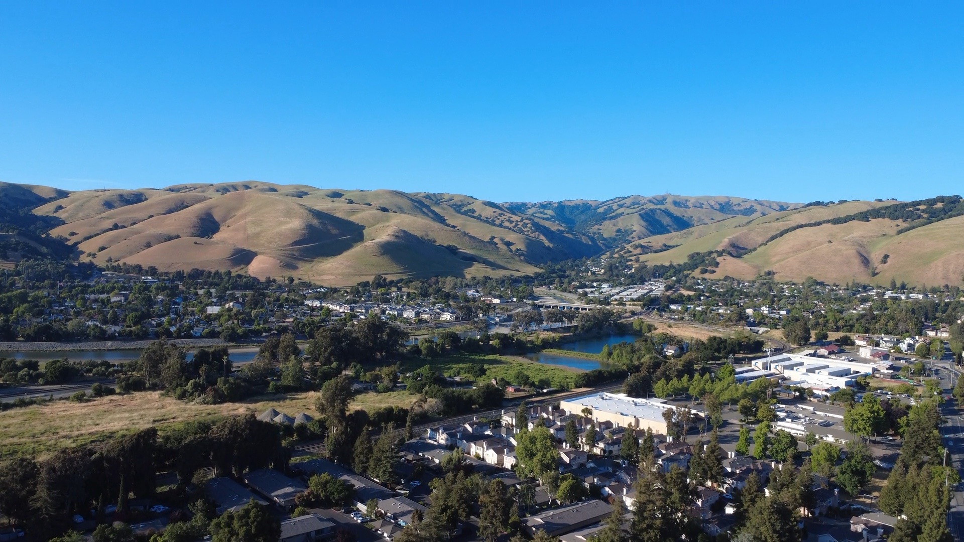 Un valle soleado de casas bajo colinas doradas